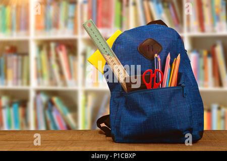 Composite image of bag with school supplies on wooden table Stock Photo