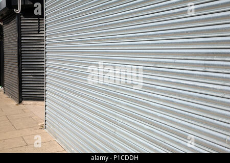 Shop front showing Shop closed with shutters down in Laughton Road Dinnington South Yorkshire Stock Photo