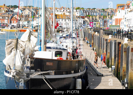 Weymouth, Dorset, UK.11th June 2018. Sailors prepare their yacht for sea on a warm and sunny morning in Weymouth harbour Credit: stuart fretwell/Alamy Live News Stock Photo