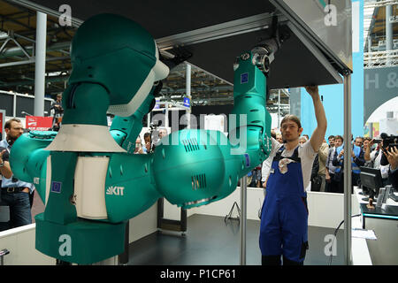 Hannover, Germany. 11th June, 2018. A robot helps a worker to disassemble ceiling during the CeBIT in Hannover, Germany, on June 11, 2018. The world's largest trade exhibition for computer technology CeBIT opened on Monday in Hannover. Credit: Wang Qing/Xinhua/Alamy Live News Stock Photo