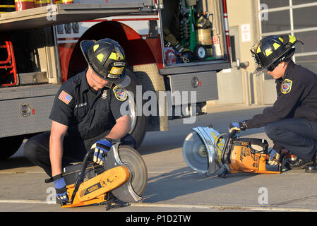 (left to right) Aron Chaney and Richard Breitenstein, both firefighters with the 788th Civil Engineer Squadron perform initial checks of their Partner rescue saws during a morning routine inspection at Wright-Patterson Air Force Base, Ohio, Oct. 12, 2016. Power saws are the “go to” tools in many operations on the fireground. (U.S. Air Force photo by Michelle Gigante/Released) Stock Photo