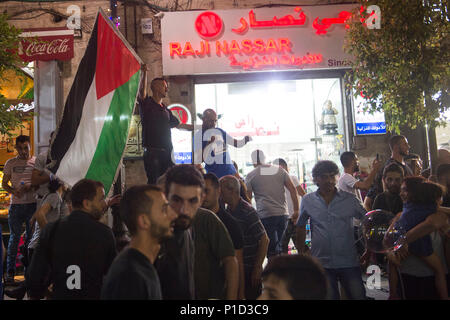 A man waves a Palestinian flag during an anti-Mahmoud Abass protest. Palestinians gathered in Al-Manara Square to march in protest of Mahmoud Abass and the Palestinian Authority. A group of pro-Abass supporters briefly scuffled with protesters, however the march remained peaceful after.