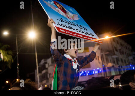 An anti-Abass protester holds a sign depicting Razan Al-Najar a nurse who was killed on during clashes at the Israeli-Gaza border. Palestinians gathered in Al-Manara Square to march in protest of Mahmoud Abass and the Palestinian Authority. A group of pro-Abass supporters briefly scuffled with protesters, however the march remained peaceful after. Stock Photo