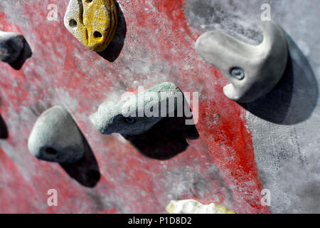 Grey wall with climbing holds in gym Stock Photo