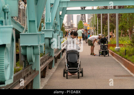 Despite the inclement weather thousands of visitors flocked to the grand opening of Domino Park in the Williamsburg neighborhood of Brooklyn in New York on Sunday, June 10, 2018. Occupying the site of the Domino Sugar Co. refinery, closed in 2004, the five-acre greenspace has water features, slides, an elevated walkway, a Danny Meyer food stand and volleyball as well as many other amenities. Designed by James Corner Field Operations, the architects behind the design of the High Line, the brick refinery building, which at one time processed 50 percent of all the sugar in the U.S. remains for de Stock Photo