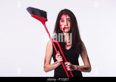 Housewife keeps a mop. Beaten young woman with bruises and blood on her