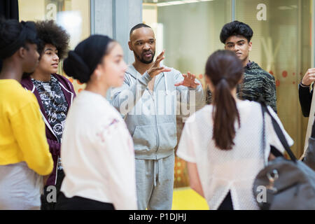 Male instructor leading teenagers in dance class studio Stock Photo