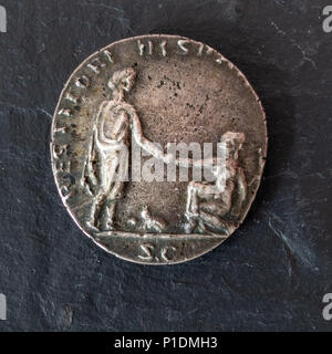 Roman Silver Denarius Coin of Emperor Hadrian - Reverse Side Showing the Emperor reaching down to Gaul Stock Photo