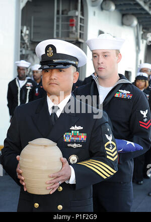 161021-N-VD165-145 PACIFIC OCEAN (Oct. 21, 2016) Senior Chief Petty Officer Jason Duque and Petty Officer 2nd Class Martin Delo carry cremains and a folded Ensign during a burial-at-sea ceremony aboard amphibious assault ship USS Boxer (LHD 4).  During the ceremony the cremains of sixteen deceased service members were committed to the sea. Boxer is currently underway conducting routine operations off the coast of Southern California. (U.S. Navy photo by Petty Officer 2nd Class Jose Jaen/Released) Stock Photo