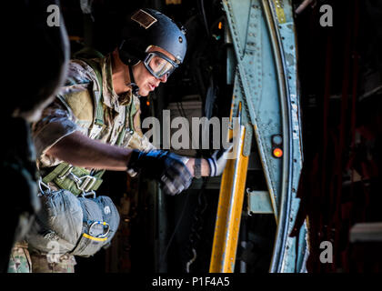 Staff Sgt. Justin Bender, 374th Operations Support Squadron survival, evasion, resistance and escape specialist prepares to perform a static line jump out of a C-130 Hercules on 26 Oct. 2016, at Yokota Air Base, Japan. SERE specialists conduct regular jump training to stay qualified and mission ready. (U.S. Air Force photo by Airman 1st Class Donald Hudson/Released) Stock Photo