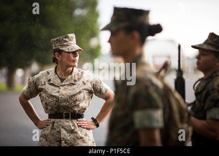 Staff Sergeant Karin Guajardo, a Sergeant Instuctor with Charlie Company, observes candidates as they practice close-order drill at Officer Candidate School, Marine Corps Base Quantico, Virginia on Oct. 21, 2016. Close-order drill is one of the key elements to teaching candidates teamwork and discipline. (Official U.S. Marine Corps photo by Sgt. John A. Martinez Jr.) Stock Photo