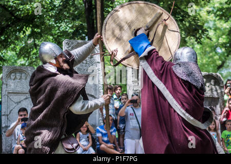 Nis, Serbia - June 10, 2018: Two knights in armor fighting in nature with old weapon. Medieval Festival battle concept Stock Photo