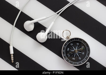 headphones and compass on black and white background, close-up Stock Photo