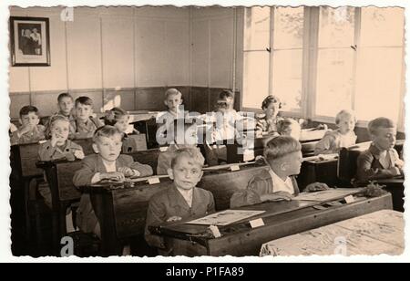 THE CZECHOSLOVAK SOCIALIST REPUBLIC - CIRCA 1950s: Retro photo shows pupils sit at the wooden school desks in the classroom. Stock Photo