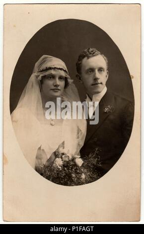 CHRASTAVA (KRATZAU), THE CZECHOSLOVAK  REPUBLIC - CIRCA 1930s: Vintage photo of newlyweds. Bride wears a veil. Old black & white photo. Antique studio portrait. Photo is oval shape. Stock Photo