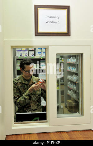 Capt. Sarah Steger, pharmacist with the 31st Combat Support Hospital and Olympia, Wa. native, verifies a prescription Oct. 25, 2016 at Camp Arifjan, Kuwait. Kim along with a small team of Soldiers operate the 31st CSH pharmacy providing pharmaceutical support to patients suffering from injuries and illnesses throughout the ARCENT area of operations. The team processes more than 3,500 outpatient prescriptions a month to service members and civilians while providing support to inpatient care and other facilities throughout the region. (U.S. Army photo by Sgt. Aaron Ellerman) Stock Photo