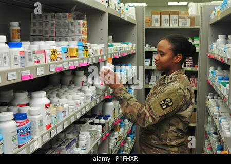 Sgt. Jessica Evans, pharmacy specialist with the 31st Combat Support Hospital and Clewiston, Fla. native, restocks pharmacuticals Oct. 25, 2016 at Camp Arifjan, Kuwait. Evans along with a small team of Soldiers operate the 31st CSH pharmacy providing pharmaceutical support to patients suffering from injuries and illnesses throughout the ARCENT area of operations. The team processes more than 3,500 outpatient prescriptions a month to service members and civilians while providing support to inpatient care and other facilities throughout the region. (U.S. Army photo by Sgt. Aaron Ellerman) Stock Photo