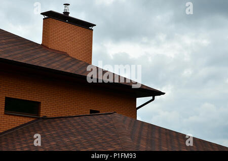 The house is equipped with high-quality roofing of shingles (bitumen tiles). A good example of perfect roofing. The roof is reliably protected from ad Stock Photo