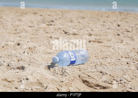A plastic Water bottle on the beach in a sunny day. Polution. Environmental issue. Stock Photo
