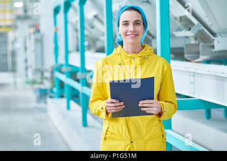 Cheerful Young Woman at Factory Stock Photo