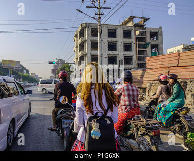 Mandalay, Myanmar - Feb 10, 2017. People riding motorbikes on street at downtown in Mandalay, Myanmar. Stock Photo