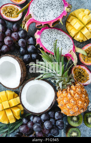 Exotic or tropical fruits assortment. Pineapple, coconut, passion fruit, pitaya, grapes and kiwi. Group of fresh fruits. Fruit background Stock Photo