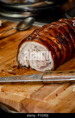 Beef and pork roll meat with smoked ham and cheese inside with a honey topping on a wooden plate Stock Photo