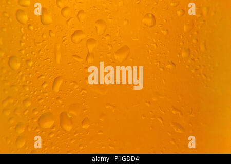 Macro shot of a beer glass with cold drops falling down. Stock Photo