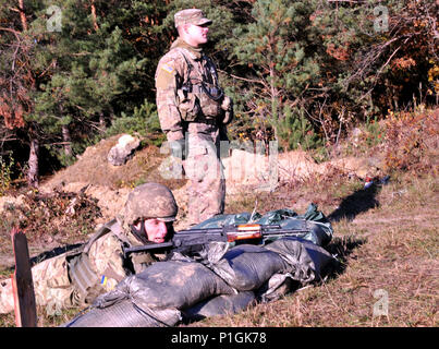 YAVORIV, Ukraine--Spc. David Mitchell from 6th Squadron, 8th Cavalry Regiment, 2nd Infantry Brigade Combat Team, 3rd Infantry Division observes Ukrainian soldiers from 1st Battalion, 80th Airmobile Brigade during a buddy live-fire training event at the International Peacekeeping and Security Center Oct 28. Task Force Mustang is deployed in support of the Joint Multinational Training Group-Ukraine. JMTG-U is focused on direct training of Ukrainian ground forces in the near term while helping to build an enduring and sustainable training capacity for the future. (Army photo by Staff Sgt. Elizabe Stock Photo