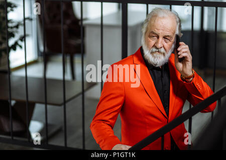 closeup portrait of senior chief talking on the phone and standing on the stair Stock Photo