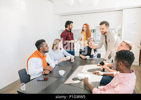 bearded guy is debating with black man during the break at work Stock Photo