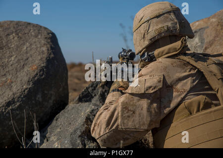 Pfc. Elmer Perez, a scout rifleman with 1st Light Armored Reconnaissance Battalion, 1st Marine Division, takes up a defensive position during a field exercise aboard Marine Corps Base Camp Pendleton, Calif., Oct. 25, 2016. The exercise was held as part of a week-long Marine Corps Combat Readiness Evaluation to ensure combat readiness before deployments. Marines maintain coverage over an area and stay alert of any enemy activity while in their defensive positions. (U.S. Marine Corps photo by Cpl. Justin Huffty) Stock Photo