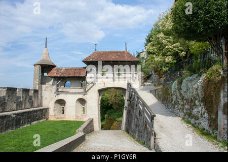 Gruyere old town in the Swiss canton of Fribourg. Medieval stone walls, ramparts and arched gate with blue sky background Stock Photo