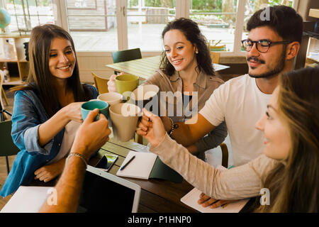 Group of friends studying together and making a toast with coffee Stock Photo