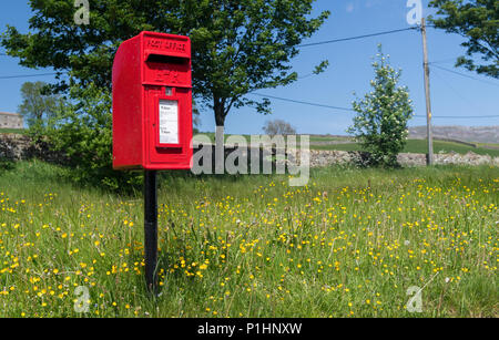 Red post box in a rural situation, North Yorkshire, UK. Stock Photo