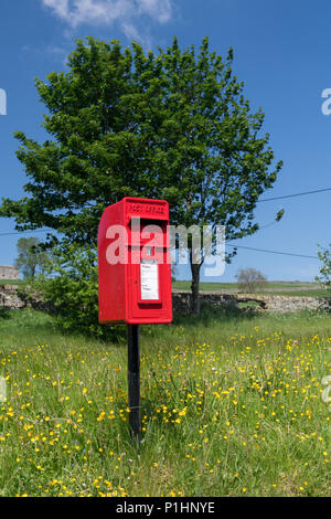 Red post box in a rural situation, North Yorkshire, UK. Stock Photo