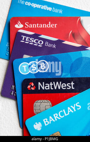 Five visa debit cards in a pile on a white background including Tesco, TSB, Barclays, Co-op, NatWest and Santander. Stock Photo