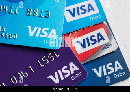 Five visa debit cards in a pile on a white background including Tesco, TSB, Barclays, Co-op, NatWest and Santander. Stock Photo