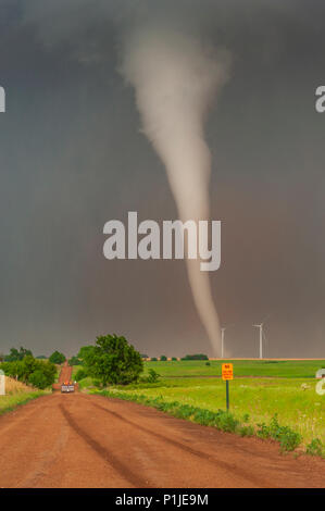 Pickup drives over mud road with a close tornado in a wind farm near Rago, Kingman County, Kansas, USA on May 19th 2012 Stock Photo