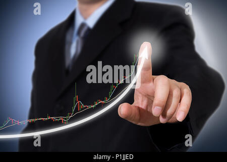 Businessman Touching a Graph Indicating Growth. Stock Photo