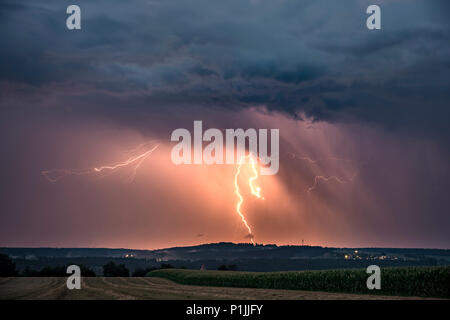 Cloud-to-ground lightning illuminated precipitation on the backside of a leaving supercell near Feuchtwangen, Baden-Wuerttemberg, Germany Stock Photo
