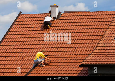 Men working on the roof of a building Stock Photo