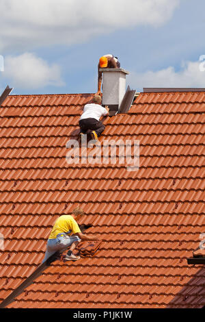 Men working on the roof of a building Stock Photo