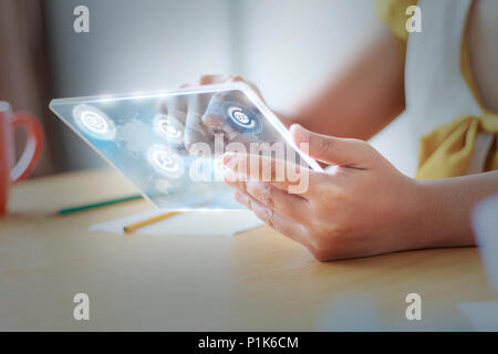 Close up shot Asian woman using clear tablet for futuristic cyber technology concept with HUD GUI User interface element hallow depth of field Stock Photo