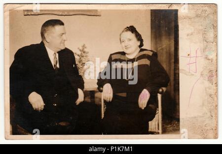 KLATOVY, THE CZECHOSLOVAK REPUBLIC - CHRISTMAS, CIRCA 1950s: Vintage photo shows an elderly couple during the Christmas. Black & white antique photography. 1950s Stock Photo