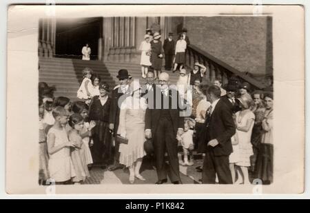 PRAGUE, THE CZECHOSLOVAK  REPUBLIC -  JUNE 28, 1930: Vintage photo shows elderly newlyweds in front of church after wedding ceremony. Black & white antique photography. 1930s Stock Photo