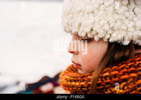 Portrait of a girl standing in the snow wearing a woolly hat Stock Photo