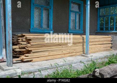 Stack of new wooden studs in the courtyard of a rural house Stock Photo