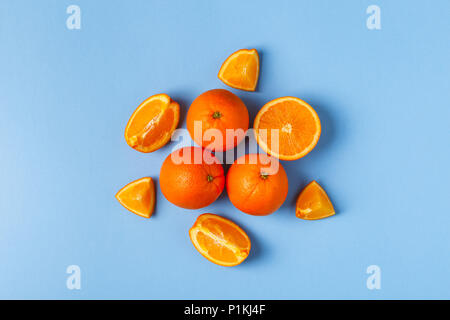 Oranges and juice on a blue pastel background, top view. Stock Photo