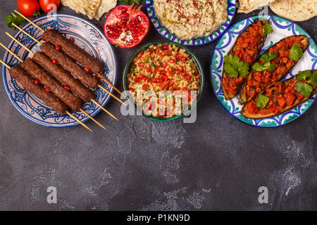 Classic kebabs, tabbouleh salad, baba ganush and baked eggplant with sauce. Traditional middle eastern or arab dish. Top view. Stock Photo